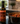 Olive oil bottle on a kitchen counter with a crock pot of chilli and a jar of basil leaves