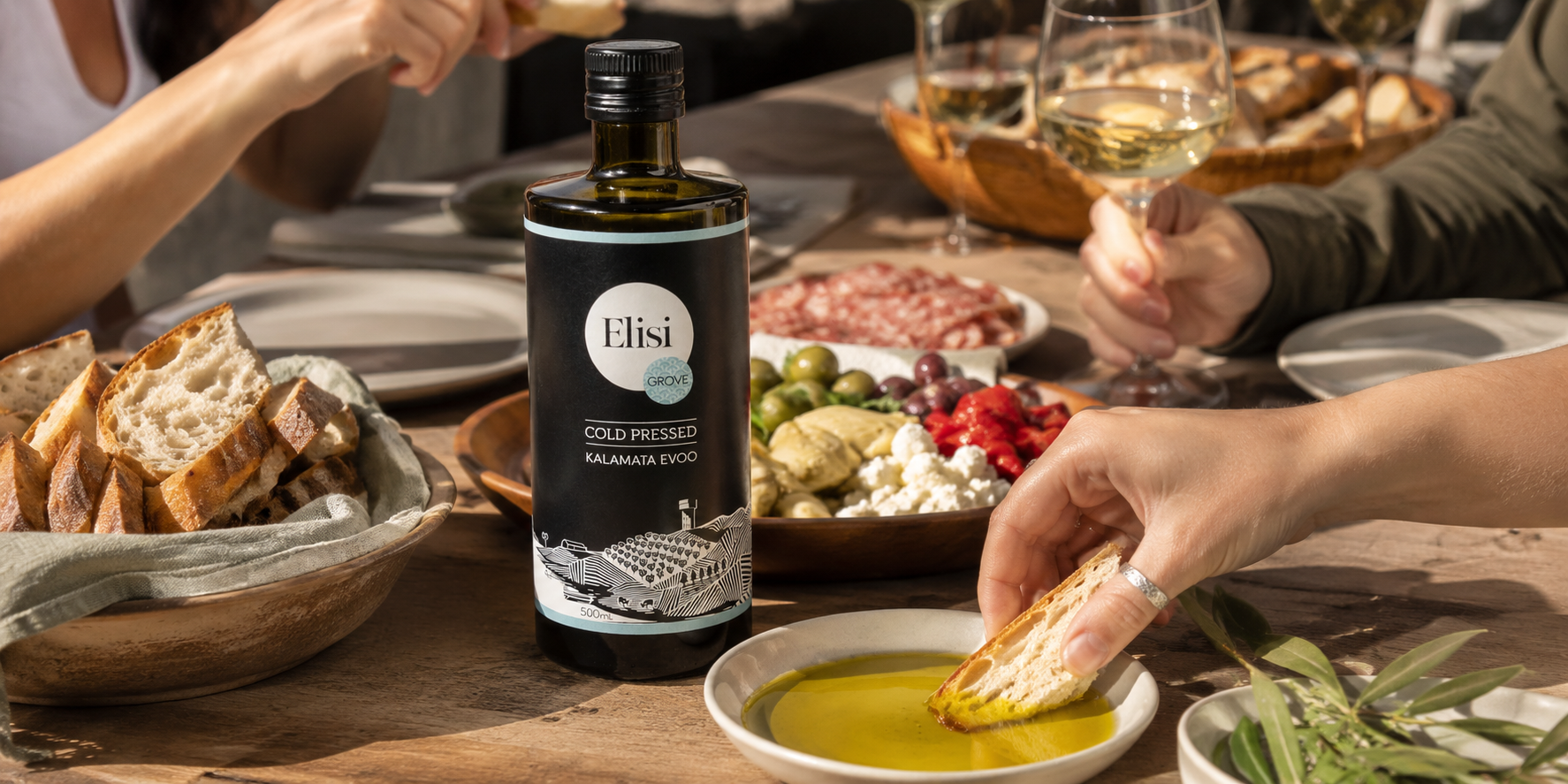 Bottle of olive oil on a table with people enjoying food and drinks