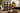 Three bottles of Rio Vista 'Nothin' But Olives' extra virgin olive oil in different flavours displayed on a rustic kitchen counter next to a prepared pasta dish, with a stove and tiled background.